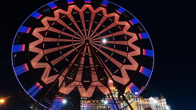 Erstaunlich beleuchtetes Riesenrad und Hotel Bogatyr nachts im Olympiapark von Sotschi Russland