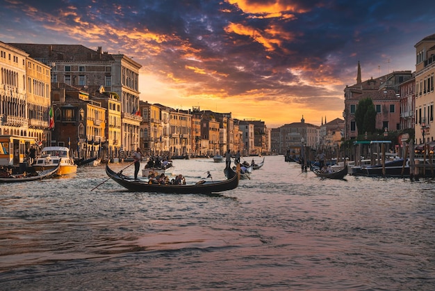 Erstaunliche Aussicht auf das schöne Venedig, Italien. Traditionelle Gondeln, die bei Sonnenuntergang den berühmten Canal Grande hinunterfahren.