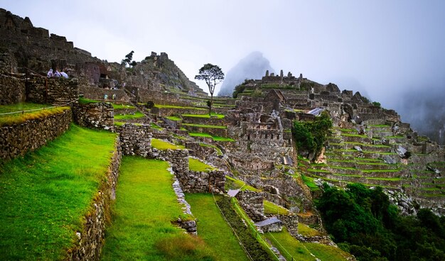 Erstaunliche Aussicht auf die majestätische Machupicchu-Tempellandschaft, die im Hintergrund mit Nebel bedeckt ist