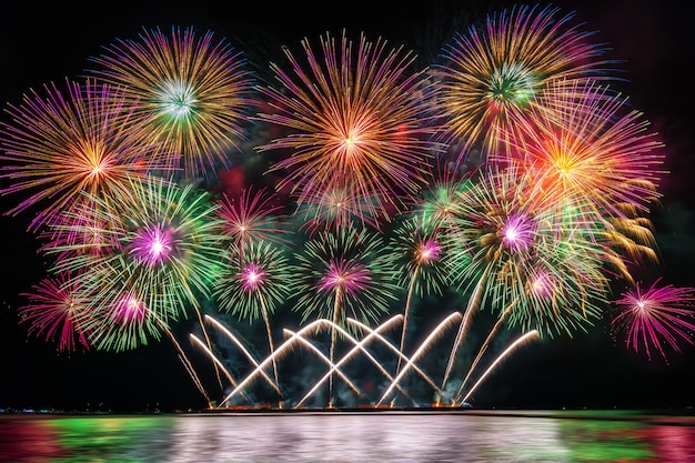 Erstaunliche bunte Feuerwerke, die für Feier vom großen Boot über dem Meer explodieren
