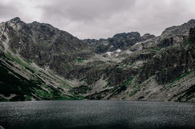 Erstaunliche felsige Berge mit Wolken und See im Sommer für Reisen