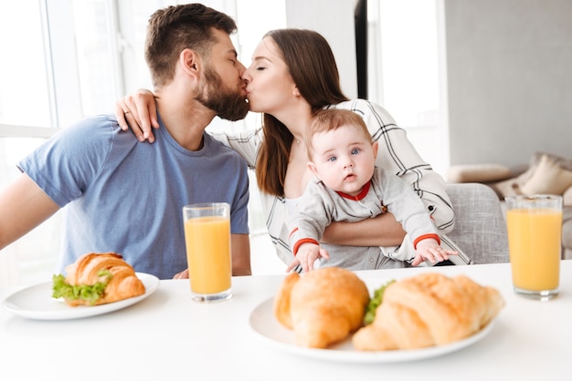 Erstaunliche junge liebende Paareltern mit ihrem kleinen Baby