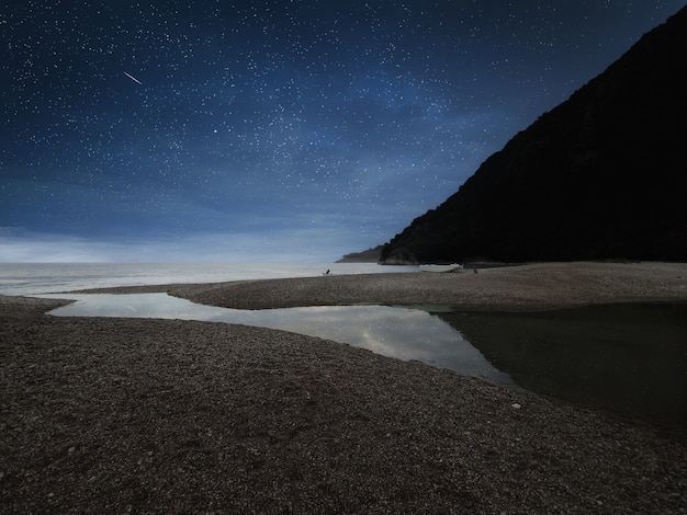 Erstaunliche Landschaft des Berges nahe dem Meer mit Steinstrand und blauem Sternenhimmel. Olimpos Strand, Türkei.