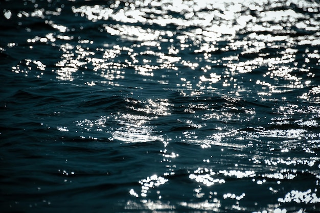 Erstaunliche Textur und Hintergrund von Meer- und Ozeanwasser und Wellen in magischen Sonnenstrahlen