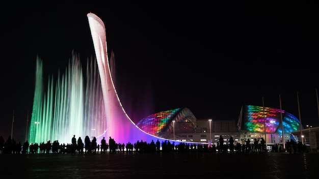 Erstaunlicher beleuchteter musikalischer Brunnen und Olympiastadion "Fisht" nachts in Sotschi, Russland.