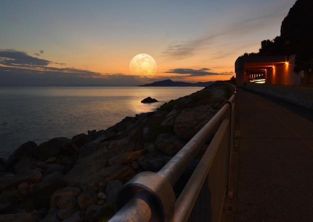 Erstaunlicher riesiger Mond, der sich auf dem Meer an der ligurischen Küste widerspiegelt