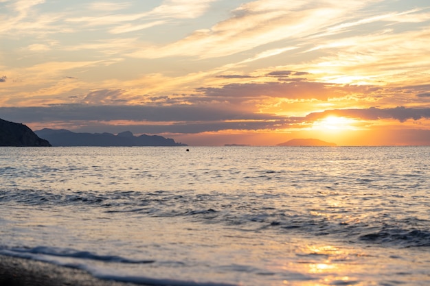 Erstaunlicher Sonnenaufgang über dem tropischen Strand. Gelbe Sonne über Meer. Orangefarbene Wellen. Natur Hintergrund. Schöne ruhige Szene. Morgen. Sonnenlicht reflektiert auf der Wasseroberfläche