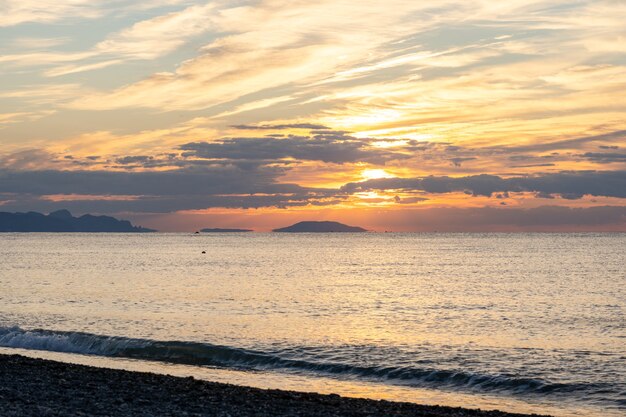 Erstaunlicher Sonnenaufgang über dem tropischen Strand. Gelbe Sonne über Meer. Orangefarbene Wellen. Natur Hintergrund. Schöne ruhige Szene. Morgen. Sonnenlicht reflektiert auf der Wasseroberfläche