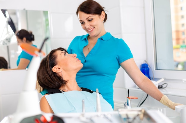 Erstaunliches Lächeln Draufsicht des Zahnarztes, der seinen schönen Patienten in der Zahnarztpraxis untersucht