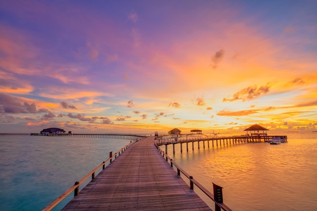 Erstaunliches Sonnenuntergangspanorama auf den Malediven. Luxus-Resort-Villen-Seelandschaft mit sanften LED-Leuchten, bunter Himmel