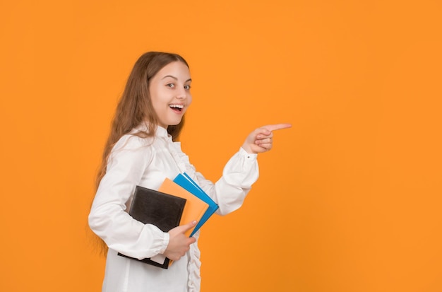 Erstauntes Kind mit Buchzeigefinger auf Kopierraum zurück zur Schulerziehung