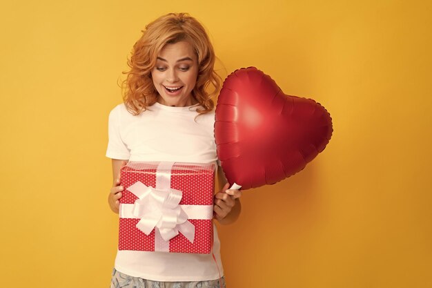 Erstauntes rothaariges Mädchen mit Liebesherzballon und Box sei mein Valentinsgruß