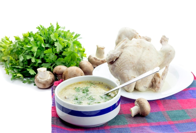 Erste Mahlzeit Pilzsuppe in einer Schüssel und gekochtes Hähnchen auf einer Tischnahaufnahme auf weißem Hintergrund