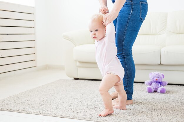 Erste Schritte. Kleines Baby, das laufen lernt. Studioshooting auf weißem Hintergrund