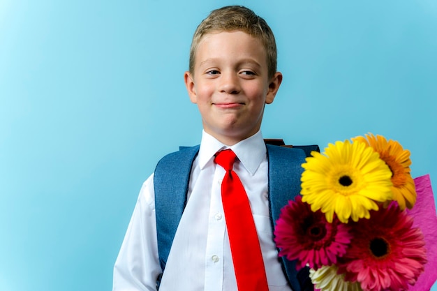 Erstklässler mit Rucksack hält einen Blumenstrauß in der Hand