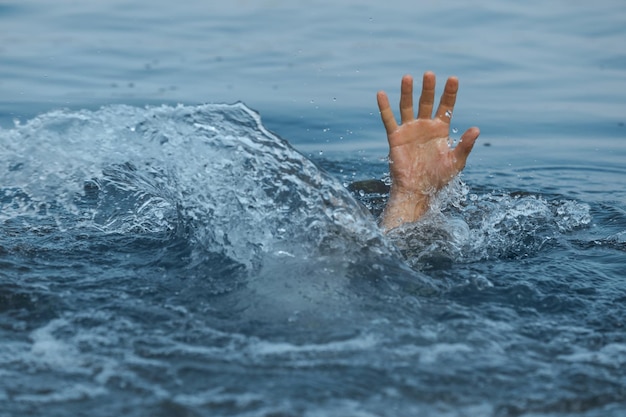 Ertrinkender Mann, der in der Nähe des Meeres nach Hilfe greift