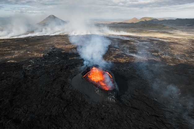 Erupción volcánica en Islandia cratera de cumbre expulsión de gas y lava derretida que se derrama de un respiradero