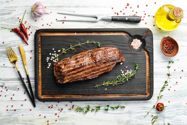 Ervas e especiarias de bife de bife grelhado Vista superior com espaço para copiar texto em um fundo de madeira