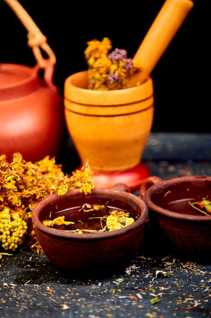 Ervas medicinais na mesa de madeira preta, fitoterapia