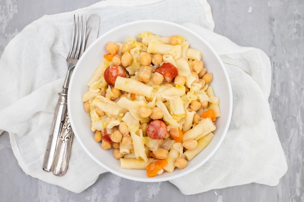 Foto ervilha com salsichas fumadas pasta e repolho em tigela branca