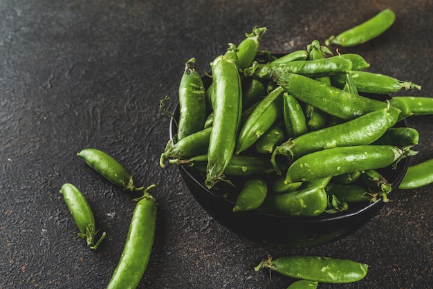 Ervilha verde fresca crua na tigela preta