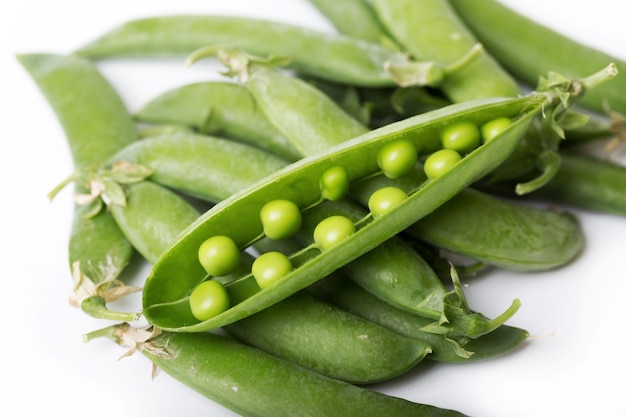 Ervilhas verdes em um fundo branco. dieta crua