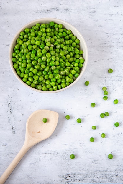 Ervilhas verdes em um prato na mesa da cozinha