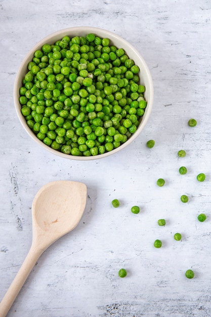 Ervilhas verdes em um prato na mesa da cozinha