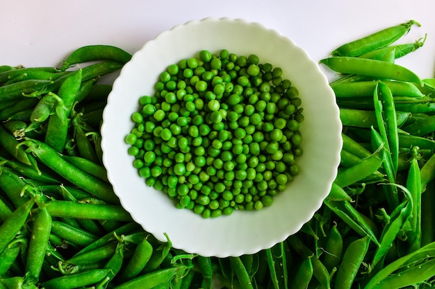 Ervilhas verdes em uma tigela branca descascadas e em tortas O conceito de nutrição adequada