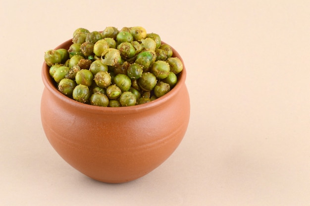 Ervilhas verdes fritas com tempero {chatpata matar} petisco indiano. ervilhas verdes salgadas secas em panela de barro.