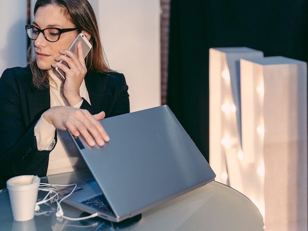 Erwachsene Frau, die ein Gespräch beim Schließen ihres Laptops hat