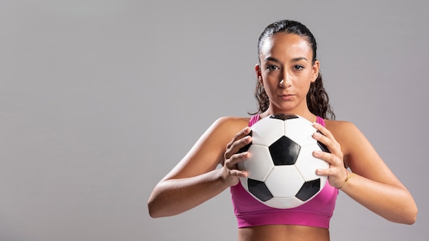 Foto erwachsene frau, die fußball hält