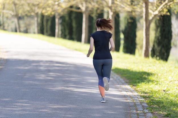 Erwachsene Frau, die im Park joggt