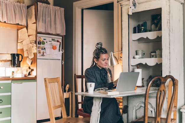 Erwachsene Frau drinnen zu Hause mit Computer