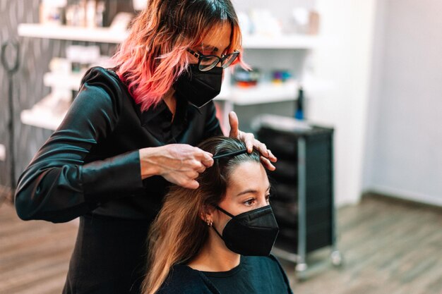 Erwachsene Frau im Friseursalon, die sich von einem Profi die Haare machen lässt