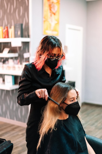 Erwachsene Frau im Friseursalon, die sich von einem Profi die Haare machen lässt