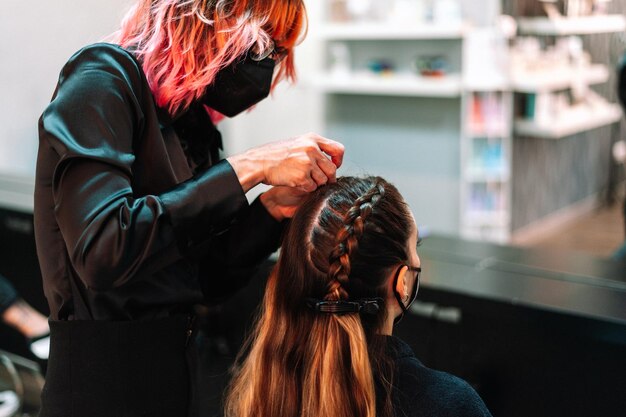 Erwachsene Frau im Friseursalon, die sich von einem Profi die Haare machen lässt