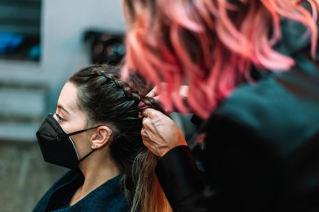 Erwachsene Frau im Friseursalon, die sich von einem Profi die Haare machen lässt