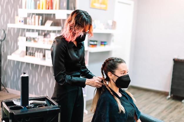 Erwachsene Frau im Friseursalon, die sich von einem Profi die Haare machen lässt