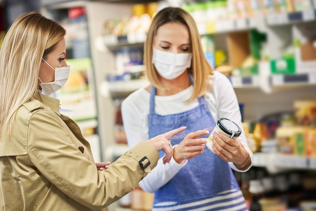 erwachsene Frau in medizinischer Maske beim Einkaufen von Lebensmitteln