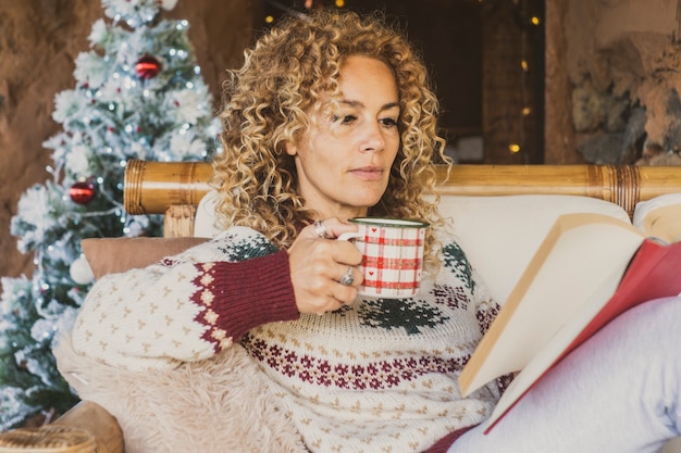 Erwachsene Frau liest Buch in den Weihnachtsferien zu Hause