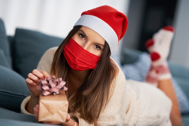 erwachsene Frau mit Weihnachtsgeschenk zu Hause