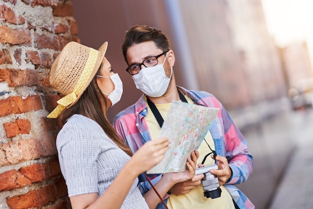 Foto erwachsene glückliche touristen in masken, die danzig polen im sommer besichtigen?