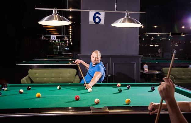 Erwachsene Männer mit Behinderungen im Rollstuhl spielen Billard im Club