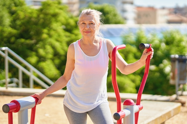 Erwachsene Sportfrau, die draußen Übungen macht.