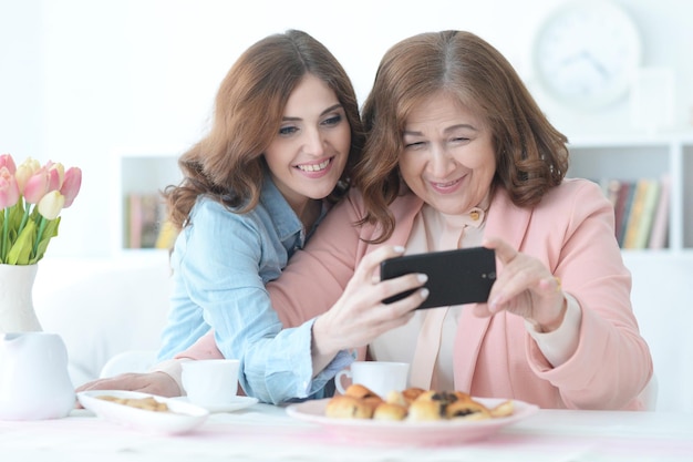 Erwachsene Tochter bringt einer älteren Mutter bei, ein Mobiltelefon zu benutzen