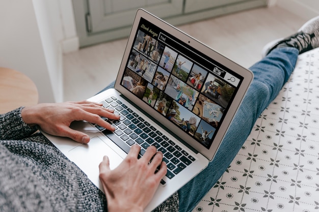 Erwachsener aus dem hohen Winkel, der auf dem Laptop nach Archivbildern sucht