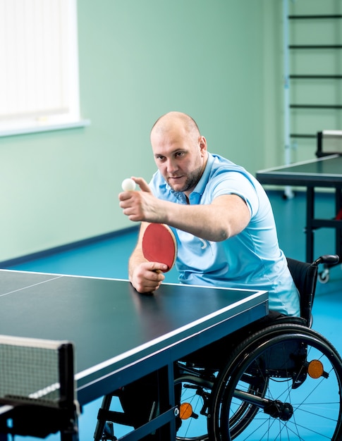 Erwachsener behinderter Mann in einem Rollstuhltraining vor dem Tischtennisspiel