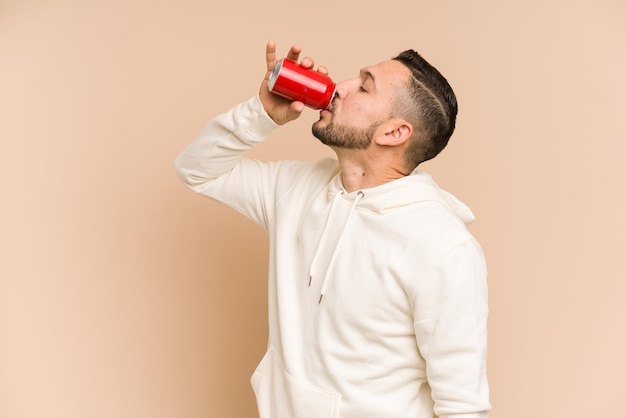 Erwachsener lateinamerikanischer Mann trinkt Cola-Erfrischung isoliert