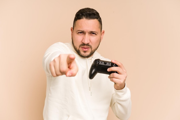 Erwachsener lateinischer Mann, der mit einem isolierten Gamecontroller spielt